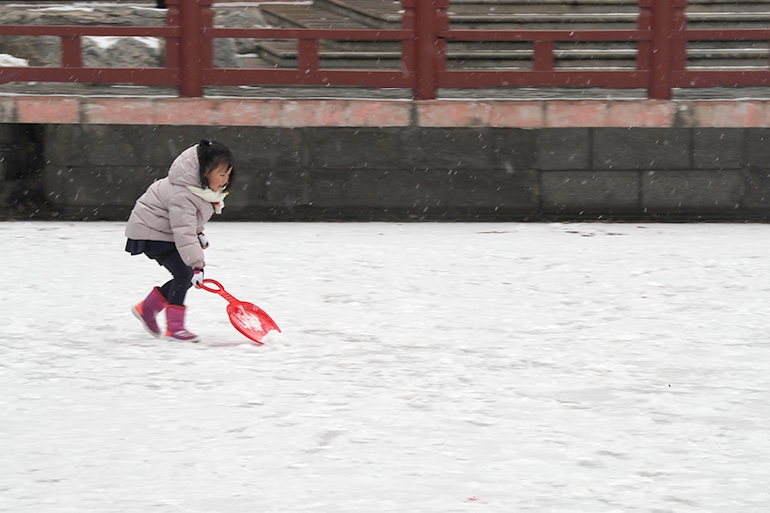 12일 오후 중국 베이징에서 눈이 내리는 가운데 한 아이가 눈장난을 하고 있다. (베이징=연합뉴스)