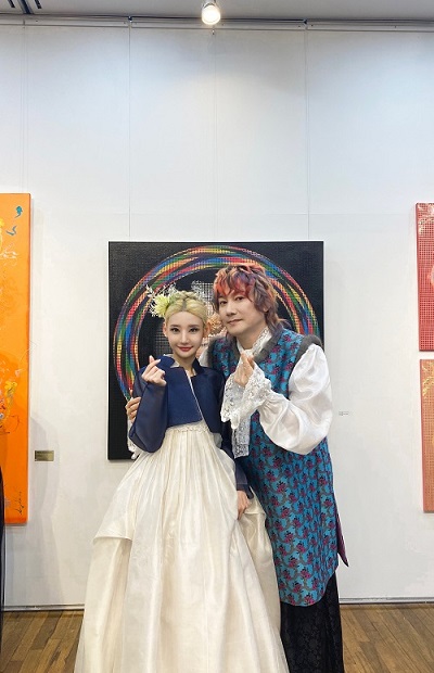 금발로 올림머리를 한 배우 채설린(Seollyn)과 알록달록한 헤어스타일로 한복을 입은 가수 김장훈이 기념 사진을 촬영하고 있다.