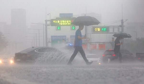 지난 13일 비가 쏟아지는 서울 여의대로 횡단보도 위로 우산을 쓴 시민들[연합뉴스 자료사진]