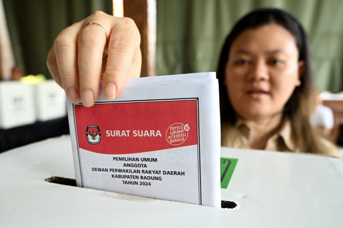 인도네시아 발리 짐바란의 한 투표소에서 한 여성이 투표함에 투표용지를 넣고 있다.[연합뉴스 제공]